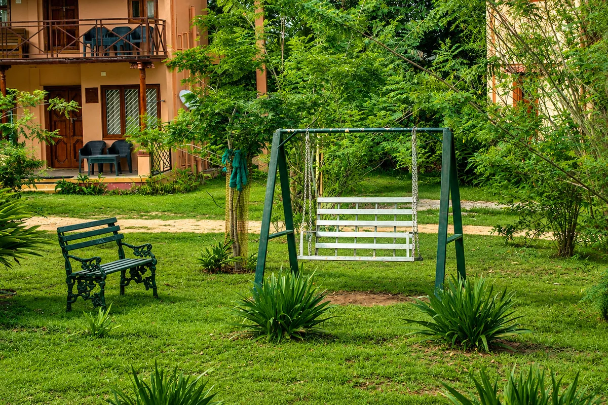 Swings and open lawn in the play area at Aranyasun