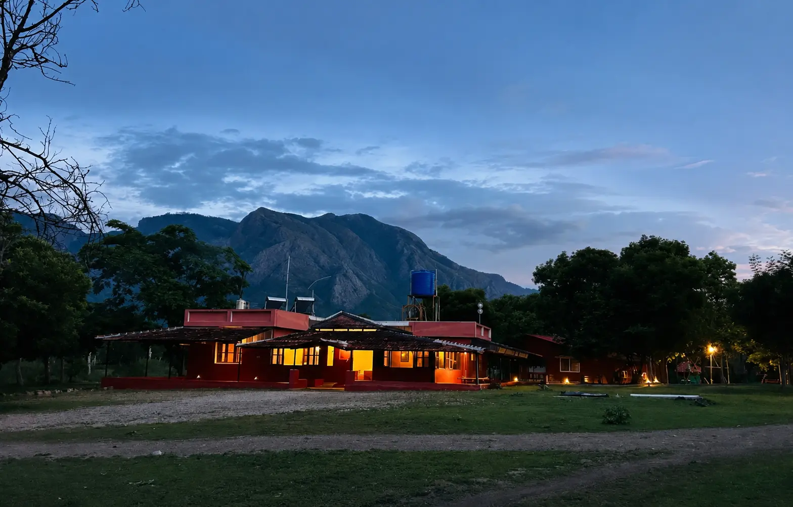 Labdhi Resorts lit at dusk with the Nilgiri hills behind it in Masinagudi