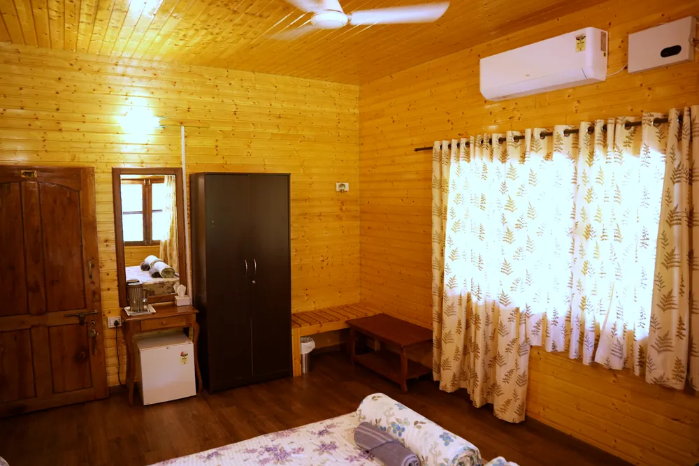 Wardrobe, dressing table with mirror and mini fridge in a Deluxe Room at Labdhi Resorts