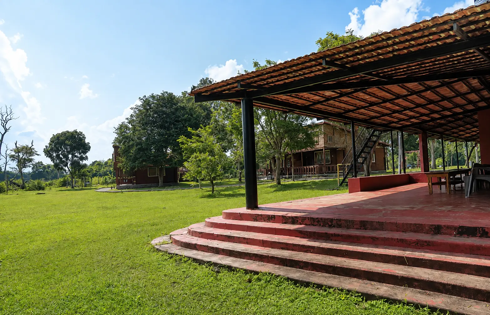 Lawn, steps and mature trees in the grounds at Labdhi Resorts