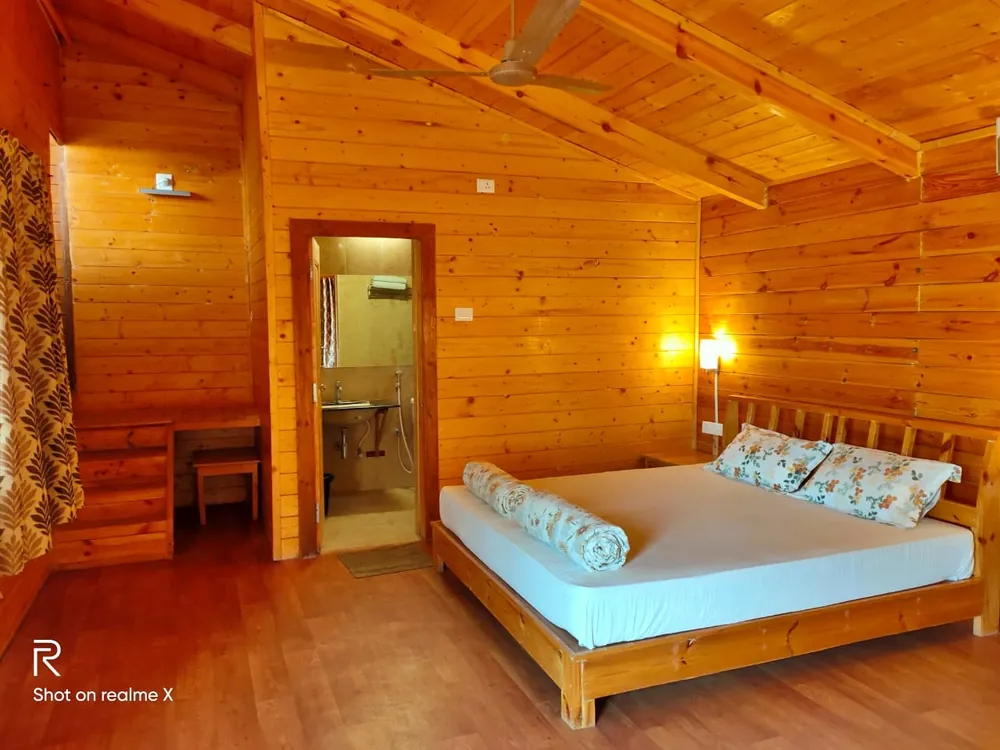 King-size bed beside the open door to the ensuite bathroom in the Superior King Room with Loft at Labdhi Resorts